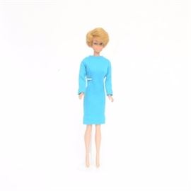 Bubble Cut European Style Barbie Circa 1963-64: A vintage European side part “bubble cut” Barbie circa 1962. This Barbie was marketed only in Europe. It features a blond European side part bubble cut hairstyle with blue eyes. This Barbie is dressed in a turquoise high collar long sleeve knee length dress with snap back.