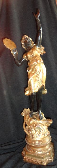 Dancing girl with tamborine on gilded pedestal.