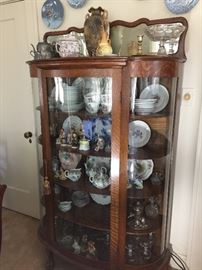 Bow front china cabinet with Haviland china, Hummel figurines, Beatrix Potter figurines 