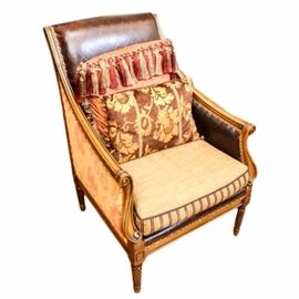 Louis XIII Style Club Chair by The Zimmerman Collection: A Louis XIII style club chair by The Zimmerman Collection. This piece has a brown leather upholstery with diamond lattice embossing to the inside of the backrest and the armrests, with printed fabric upholstery to the outside of the back and arms. The partially exposed wooden frame has incised border and scroll detail carved to the flared front stiles. The tapered legs have twist turning and end on toupie feet. It has a removable, upholstered seat cushion and accent pillows. The maker’s mark is on the decking.