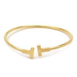 Tiffany & Co 18K Yellow Gold Tiffany T Narrow Wire Bracelet: A Tiffany & Co 18K yellow gold Tiffany T narrow wire bracelet featuring a slightly opening with “T” ends.