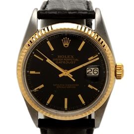 Rolex Datejust 14K Yellow Gold Bezel Black Dial Wristwatch: A 1960s Role Datejust wristwatch featuring a 14K yellow gold bezel with a stainless steel case and leather band.