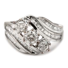 10K White Gold 0.94 CTW Diamond Ring: A 10K white gold ring showcasing three center diamonds arranged diagonally with curved shoulders additionally adorned with diamonds.