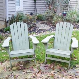 Sage Adirondack Chairs: A set of two sage green painted adirondack chairs. These outdoor wood chairs feature a slanted slat back, wide arms and angled slat seat.