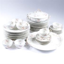 Theodore Haviland Rose China Set: An assortment of Theodore Haviland china dinnerware from Limoges France. This vintage assortment of Haviland china is decorated with soft rose designs and gold-colored embellishments. This forty-two piece set includes one serving platter, eight tea cups, twelve saucers, twenty dinner plates, and one lidded tureen.