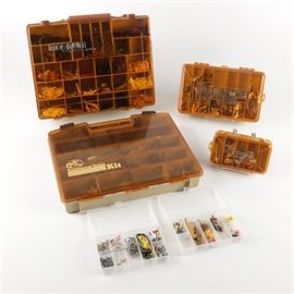 Collection of Tackle Boxes and Fishing Supplies: A collection of tackle boxes and fishing supplies. Three of the tackle boxes are made by Magnum and the other is by Bass Pro Shop. Supplies included are faux bait, lures, floaters, weights, hooks, and line.