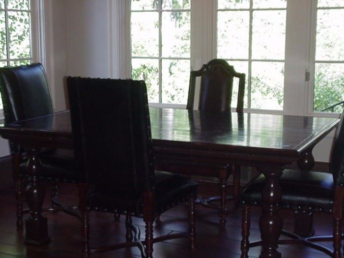 Farm table with turned legs.  Three leather chairs, also Marge Carson.  One wood chair with upholstered seat.  