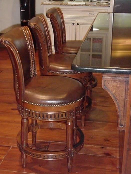 Three leather and wood bar stools with swivel seat