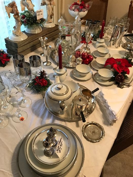 12 piece place settings of beautiful china w/ coffee and tea sets, on Dining Room table decorated for Christmas.