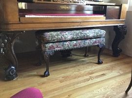 Piano bench ticked under with legs detail of piano legs