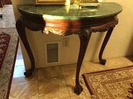 Half circle console table with  lush carved wood apron and legs, ball and claw feet green marble top