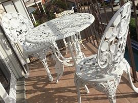 Ice cream parlor style metal table and two chairs set with roses design and a plant stand or side server that matches