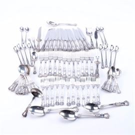 Gorham "Buttercup" Sterling Flatware Collection: A collection of sterling flatware by Gorham. These eighty-two pieces feature the Buttercup pattern, designed in 1899, with floral designs to the scalloped handle. This set includes twelve dinner forks, salad pastry forks, twelve hollow handle dinner knives with stainless steel blades, twelve round soup spoons, three tablespoons, twelve iced tea spoons, thirteen teaspoons, a carving set with hollow handles and stainless steel blades, a small pierced chipped beef fork, a pierced tablespoon, a flat handle master butter, a two-tine butter pick, a lemon fork, a sugar spoon, and a gravy ladle. These pieces are all embossed with the Gorham pseudo hallmarks and “Sterling” to the back of the stems.