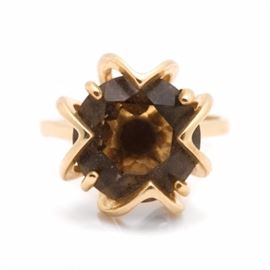 14K Yellow Gold Smoky Quartz Ring: A 14K yellow gold smoky quartz ring. This ring features a center round smoky quartz stone within an open geometric floral motif setting.