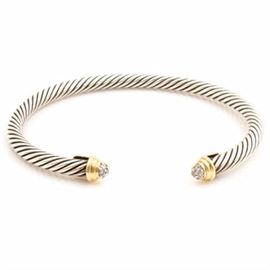 David Yurman Sterling Silver and 18K Yellow Gold Cuff Bracelet: A David Yurman sterling silver and 18K yellow gold cuff bracelet from the Cable Classics Collection. This bracelet features a twisted cable design with gold and diamond accents.