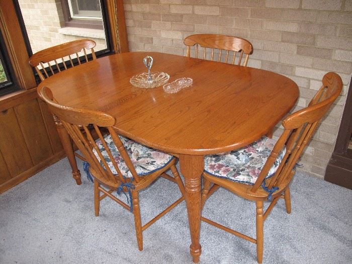 Solid Oak Dining Table 4 chairs and 2 leafs in the under side of the table