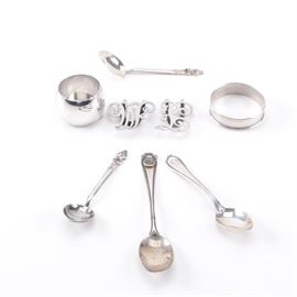 Reed & Barton "Hepplewhite" Spoon and Other Sterling Silver Tableware: An eight-piece collection of sterling silver pieces. This includes a demitasse spoon in the Charles A Bennett designed Hepplewhite pattern by Reed & Barton, first introduced in 1907, which has a personalized engraving of “MFM” to the handle. It is presented with two clips of “W” and “P” by Apollo Silver Company, a napkin ring by Gorham with engraving of “DLF” to the side, another napkin ring, an Ohio Northern University souvenir spoon by Lunt Silversmiths, and a small spoon with figural shaped tip. Each is marked for silver fineness. The total approximate weight including enameled element is 2.935 ozt.