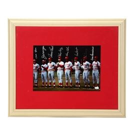 "Great Eight" Signed 1975-1976 Reds Team Framed Photo: A “Great Eight” 1975-1976 Cincinnati Reds autographed team photograph. This display has been signed by Pete Rose, (HOF) Joe Morgan, (HOF) Johnny Bench, (HOF) Tony Perez, George Foster, Dave Concepcion, Ken Griffey, and Cesar Geronimo. All signature were done in silver marker and are bold and smudge free. The autographs of Pete Rise, Ken Griffey, Joe Morgan, and Tony Perez have been professionally authenticated. The Rose autograph has been authenticated by JSA. Griffey, Perez, and Morgan have tickets from public signing events which our consignor obtained the autographs from Sports Gallery. This classic photo presents the Reds in pre-game ceremonies. Framed in white plastic and matted in red, the display is underneath plexiglass. The backside has a protective brown cardboard paper. The 1975 and 1976 Cincinnati Reds starting eight is considered by many to be one of the greatest teams ever in Major League Baseball history.