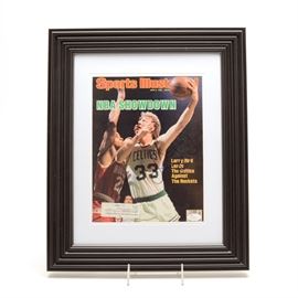 Larry Bird Signed Sports Illustrated "NBA Showdown" Magazine JSA: A signed Lary Bird Boston Celtics 1986 “Sports Illustrated” magazine. Larry signed the front cover of this magazine in blue marker. The autograph is bold and smudge free and has been professionally authenticated by JSA with hologram sticker affixed to the magazine. The date of this magazine is June 9, 1986, and depicts Larry shooting a hook shot. The title of the magazine is “NBA Showdown” highlighting the Celtics against the Rockets. The original mailing address is attached to the magazine. The display is presented in a black plastic frame with white matting underneath plexiglass. Please note, this magazine was not removed from the frame; thus not sure if it is complete. Larry Bird played his entire NBA career with the Boston Celtics. A member of the NBA’s Hall Of Fame, Larry played for team “USA” in the Olympics.
