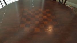 pub height table features a checkboard/chess top and comes with 4 stools