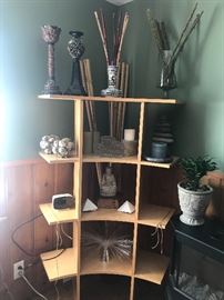 A corner shelving unit with lots of fun decorative items. 