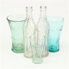 Coca Cola Glasses and La Salle Soda Bottles: A group of Coca Cola glasses and La Salle soda bottles. This lot includes three Coke items and two La Salle bottles. The fountain style Coco-Cola glasses feature a light green tinted one that has a flared mouth; all three are in graduated sizes. The clear glass vintage bottles are marked on the sides “La Salle Soda”.