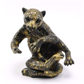 Carved Leopard Statue: A carved animal statue. This piece is composed of black resin in the shape of a leopard. The leopard features textured spots with a distressed gold-tone finish. It is unmarked.
