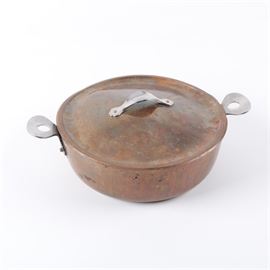 Danish Copper Cooking Pot by Cohr: A Danish copper cooking pot by Cohr. This round pan and matching lid have silver tone metal handles connected by rivets. A maker’s mark is present to the handle on the side of the pan.