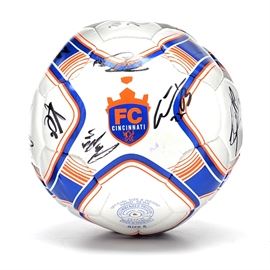 FC Cincinnati Signed Soccer Ball: An FC Cincinnati autographed soccer ball. The ball is screen-printed in the Queen City’s Professional Soccer FC colors of blue and orange with logo to center. Some of the players who signed the ball, including: Danni Konis #11, JOSU #99, Matt Bahner #2, Kyle Greis #16, Kenney Walker #6, Austin Berry #22, Aodhan Quinn #5, Dallas Jaye #30, Dan Williams #27, Aaron Walker #27, Garrett Halfhill #26, Marco Dominguez #21, Derek Luke #24, Mele Temguia #74, Omar Cummings #14, Mitch Hildebrandt, Paul Nicholson #8, Justin Hoyte #32 and Harrison Delbridge #4.