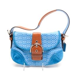 Coach Signature Soho Mini Purse: A Coach Signature Soho Mini purse. The coach signature jacquard hobo baguette purse is turquoise in color with tan leather strap and trim suede accents and retains original hang-tag. The purse is fully lined with interior zipper pocket and two slip pockets. Attached leather Coach creed tag to inside with the serial number “J04J-8818”.