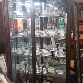 Tea Cups and Saucers and the Glass Cabinet that they are in
