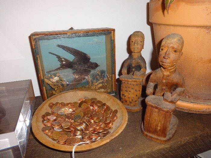 Carved colonial administrators by Thomas Ona Odulate; swallow diorama; and bowl of pennies.
