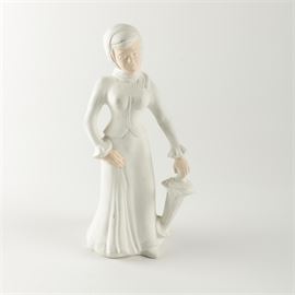 D. Grady Painted Ceramic Female Figure in Turn of the Century Attire: A painted slip cast ceramic figure by artist D. Grady. The piece depicts a female figure dressed in turn-of-the-century attire standing while holding an umbrella at her side. The work is painted entirely in matte off-white, except for the figure’s face and hands. The work is signed with an incised marking of “D. Grady” to the underside.
