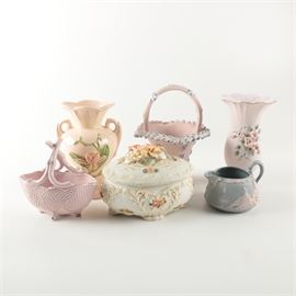 Vintage Porcelain Urns and Other Decor: A collection of vintage six pieces of porcelain decor. The collection includes a peach tone urn by Hull Art Pottery with embossed pink water lily design to the front, a pink Lefton China urn with bisque porcelain flowers in high relief to the front, and a pink Italian basket featuring a textured finish with blue flowers in relief throughout as a few highlights.