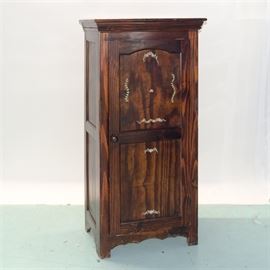 Pine Pantry Cabinet: A pine cabinet. This tall piece has a beveled cornice over paneled sides, and stands on block feet which sit between a scalloped, arched apron; the exterior is stained dark. The door has a knob handle and is decorated in a rose and garland design in light yellow, pink, and green in the two panels. The unfinished interior has two stationary shelves, and a wire basket attached to the door.