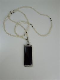 CW:  Elegant Art Deco Lorgnette 14K white gold, two rows of 8 full cut diamonds framing a black enamel face, diamond mounted bail on opera length pearl & onyx bead necklace.  Spring-loaded glasses in 14K frame. Circa 1925. 