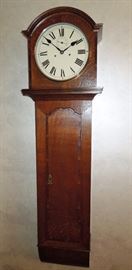 BAT:  Antique English tavern clock; oak case with mahogany crossbanding,  attractive arch-top bonnet and shaped trunk door.  Eight-day movement with seconds pendulum striking hours on a bell.  Circa 1870.  Good operating order.   64" high x 17 3/4" wide x 9 3/4" deep