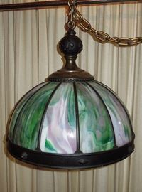 Remarkably large (22.5" diameter x 22.5" high to chain suspension) antique American bronze patinated brass and streaky slag glass hanging shade.  Circa 1920s.  Original 5-light branch arm with switches.  Massive spherical knop cast with fleur-de-lis, wide banded skirt.    One panel cracked, otherwise in fine original condition and operating order.