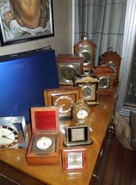 Selection of Doug's shelf and desk clocks.....Elliott, of London in hardwood and lacquer cases; high grade Swiss alarms and a mahogany boxed deck clock.