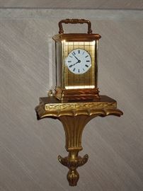 St. James, England gilded brass 8-day carriage clock of fine quality and elegant proportions - unusual matte and burnished gold dial mask.  High grade movement with fully jeweled lever escapement.  Circa 1975.  Presented on an Italian gilded terracotta bracket of neoclassical style.