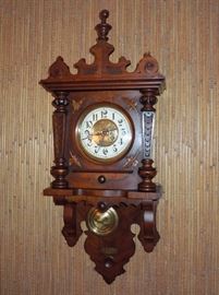 BAT:   German carved walnut "free swinger" clock with rare quarter-striking movement.  Fine condition with original headpiece.  Circa 1890.
