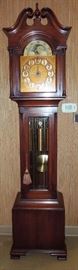 Colonial mahogany grandfather clock with rare chain suspension weight-driven German movement Westminster chiming on brass tubular bells.  Traditional case with swan's neck pediment, narrow waist door with beveled glass, base on bracket feet.  Moon-phase dial with applied Arabic numbers.  Circa 1920s.  Original finish with warm patina.  Operating order