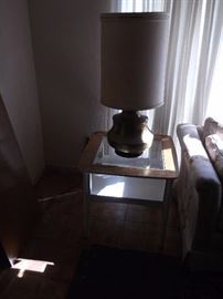 Great mid century brass lamp sitting on an oak end table with beveled glass inset and painted white base.