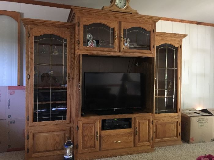 Solid oak entertainment center. Three pieces. All display cases have beautiful glass shelving and lights.