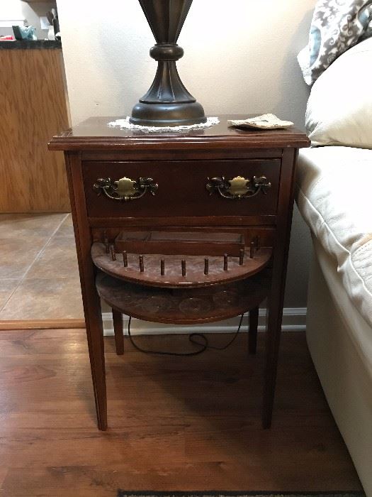 Antique sewing cabinet with bottom drawer open.