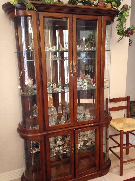 Curio cabinet loaded with collectibles including Austrian Swarovski crystal figures