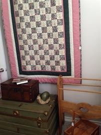 One of several quilts; trunks; quilt stand