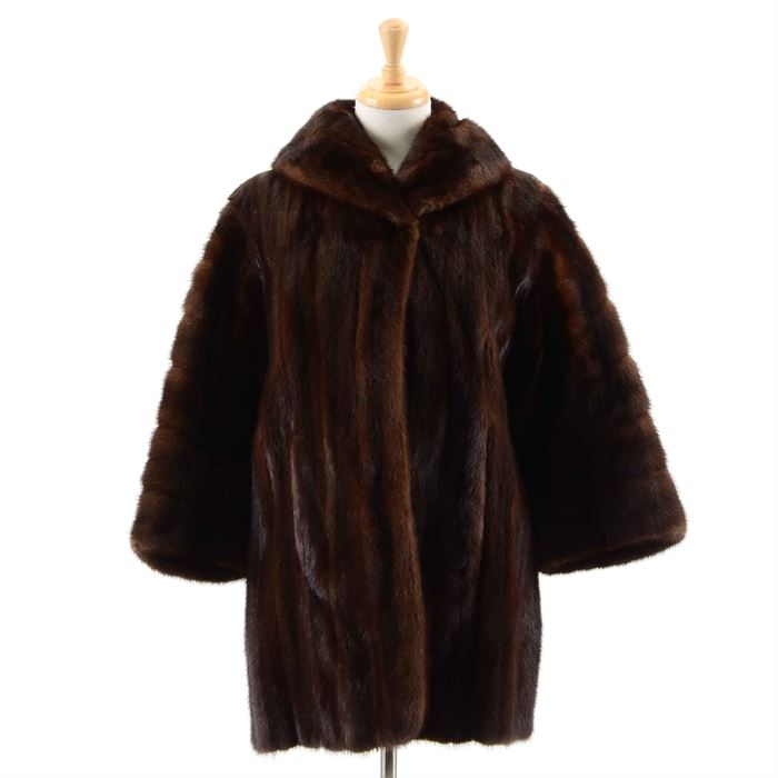 Vintage Gidding Jenny Mink Fur Coat: A mink fur coat by Gidding Jenny . This vintage swing coat comes in a warm brown color and features a shawl collar and 3/4 length sleeves. This sleek coat does not have closures or pockets. The coat is fully lined in a matching brown color with a satin tag reading “Sincerely Gidding Jenning” sewn to the interior.