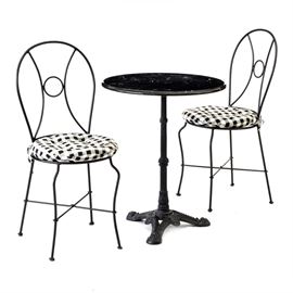 Marble Top Bistro Table and Chairs: A marble top bistro table and chairs set. The table features a pivoting black marble top with molded edge, rising on a black cast iron pedestal base. The two chairs have black iron frames with with removable black and white checked seat cushions.
