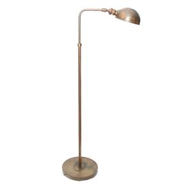 Brass Floor Lamp: A brass floor lamp. The lamp features a shell shade attached to the arm that leads down a long pole style body. The body sits on a rounded base and is not marked.